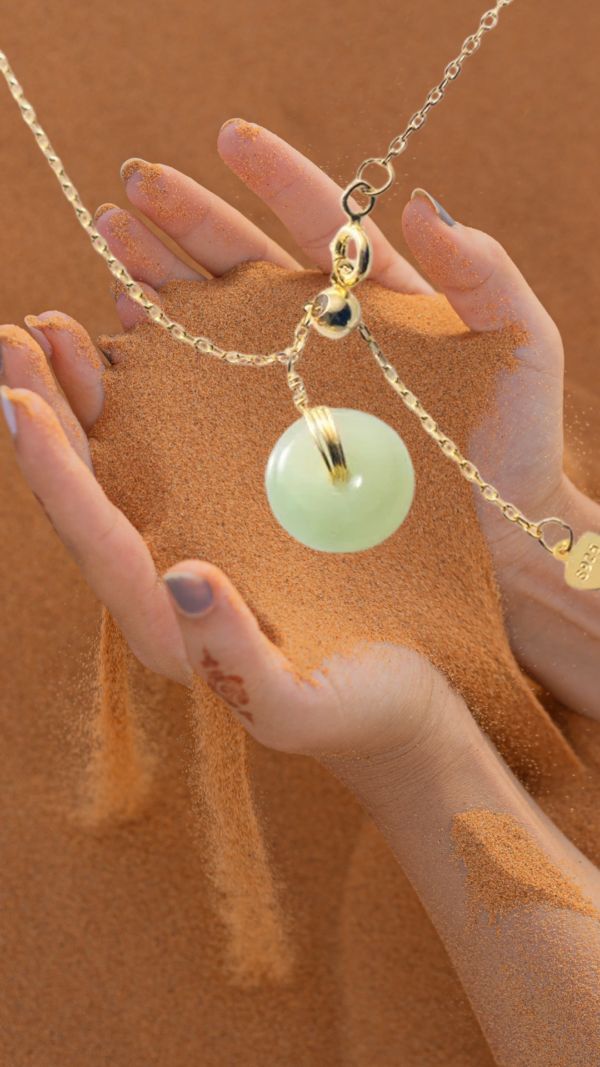 A woman hands holding a jade necklace, symbolizing success.